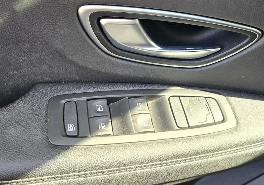 Poignée de porte intérieure et commandes des vitres sur le côté gauche d'un Renault Scenic 2020 finition Business.