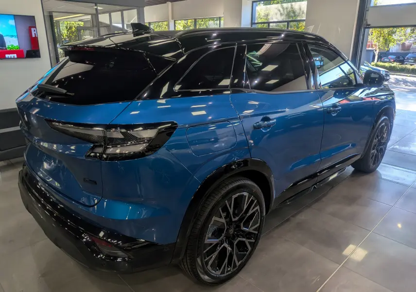 Vue 3/4 arrière droite du Renault Austral bleu outremer avec toit noir et jantes noires en concession.