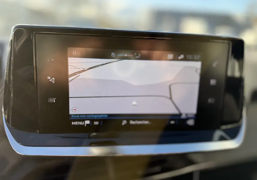 Écran tactile central du tableau de bord du Peugeot 2008 gris 2020 affichant la navigation GPS et la température extérieure.