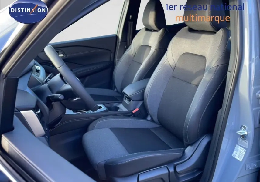 Vue intérieure côté conducteur du Nissan Qashqai gris argile métal 2025, sièges tissu bi-ton gris et noir.