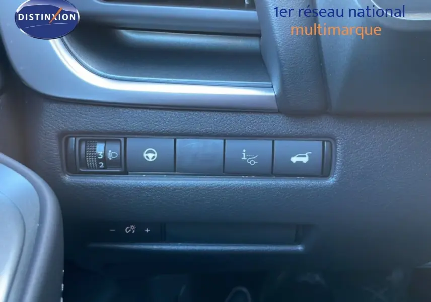 Détail intérieur montrant les commandes de réglage des phares et ouverture du hayon sur Nissan Qashqai gris argile.