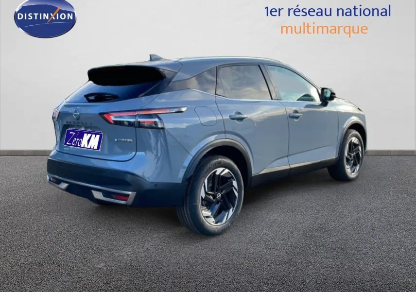 Vue 3/4 arrière droite d'un Nissan Qashqai gris argile métal 2025 avec jantes noires et toit noir.