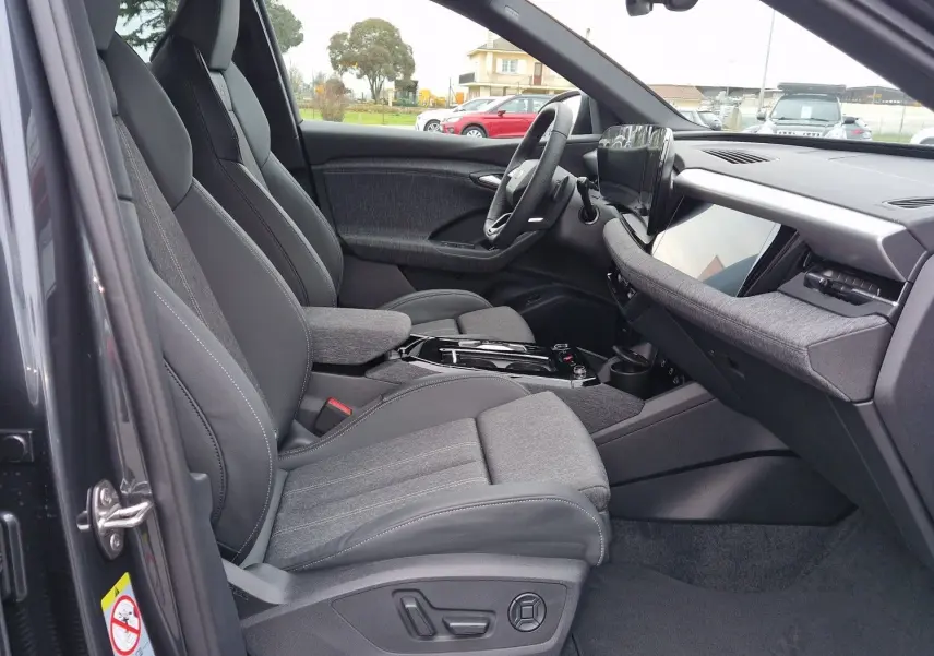 Vue intérieure côté conducteur de l'Audi Q6 e-tron Performance S-Line 2025, sièges gris et tableau de bord moderne.