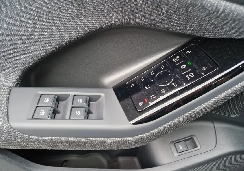 Gros plan sur la commande des vitres et réglages des rétroviseurs côté gauche de l'Audi Q6 e-tron Performance S-Line gris Manhattan.