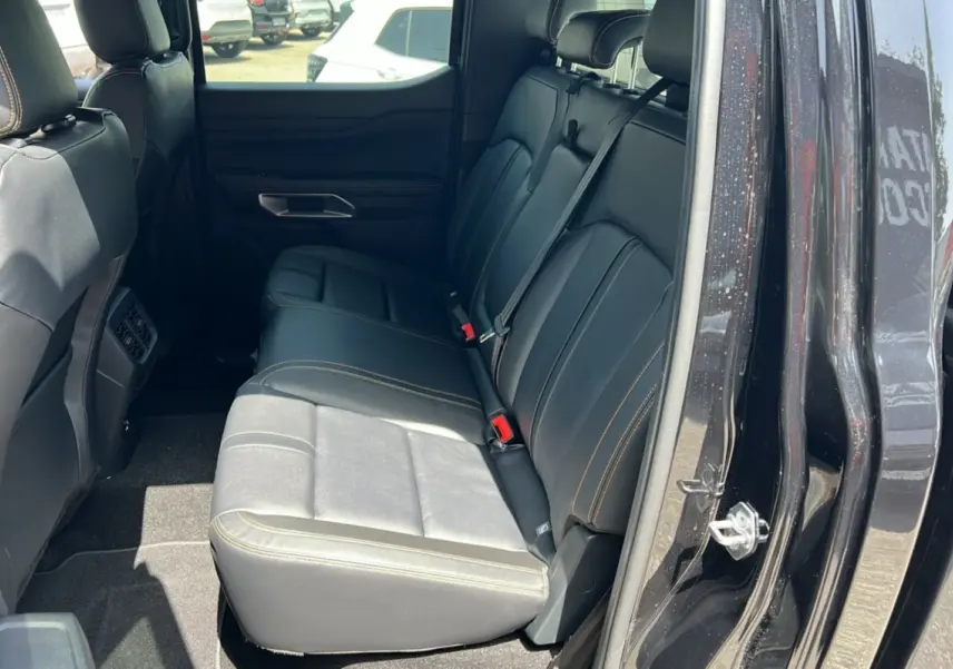 Vue intérieure côté droit sur la banquette arrière en cuir noir avec surpiqûres jaunes du Ford Ranger Wildtrak noir agate 2025.