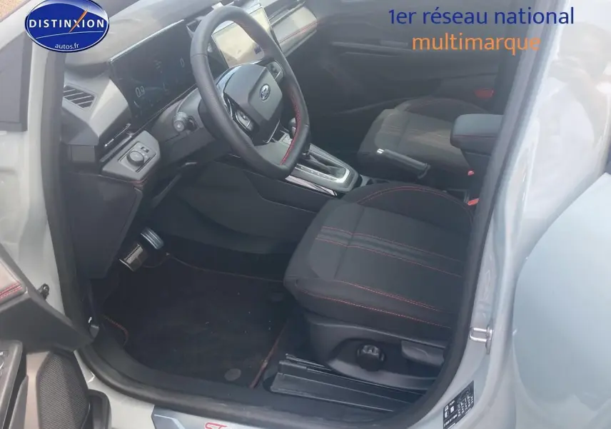 Intérieur avant droit du Ford Puma gris cactus 2025, sièges tissu noir avec surpiqûres rouges et console centrale visible.