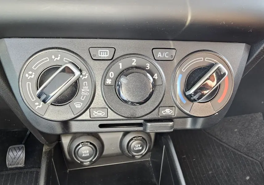 Panneau de commandes de climatisation manuel avec réglages de température, ventilation et prises USB/AUX sur Suzuki Swift 2023.