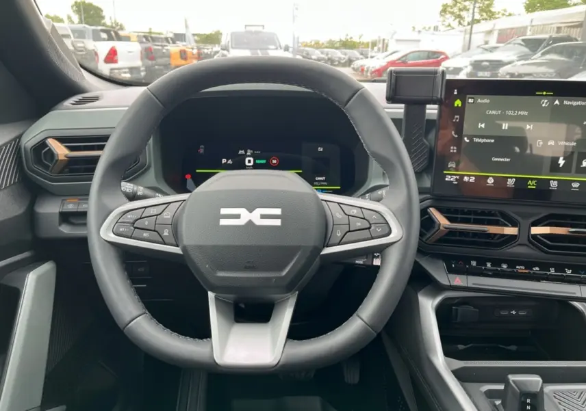 Vue intérieure centrée sur le volant cuir et le tableau de bord digital du Dacia Bigster Hybrid 155 Extreme Plus.