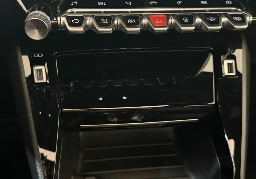 Gros plan sur la console centrale noire brillante du Peugeot 2008 GT Pack 2021 avec boutons de commande et ports USB.