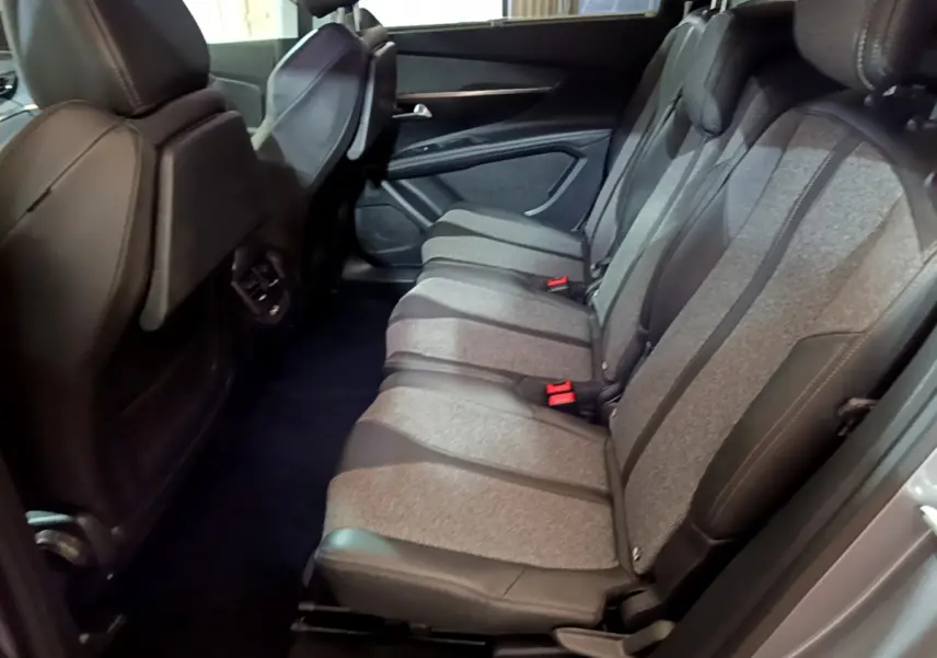 Vue latérale des sièges arrière gris clair et noirs du Peugeot 5008 2020, version Puretech Allure, avec appuie-têtes intégrés.