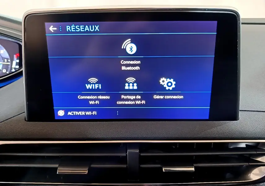 Écran tactile central du tableau de bord du Peugeot 5008 gris clair affichant les options de connexion réseau Bluetooth et Wi-Fi.