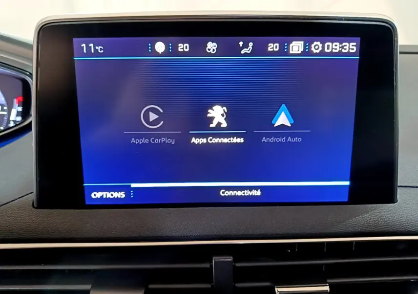 Écran tactile central affichant Apple CarPlay et Android Auto dans le tableau de bord du Peugeot 5008 gris clair.