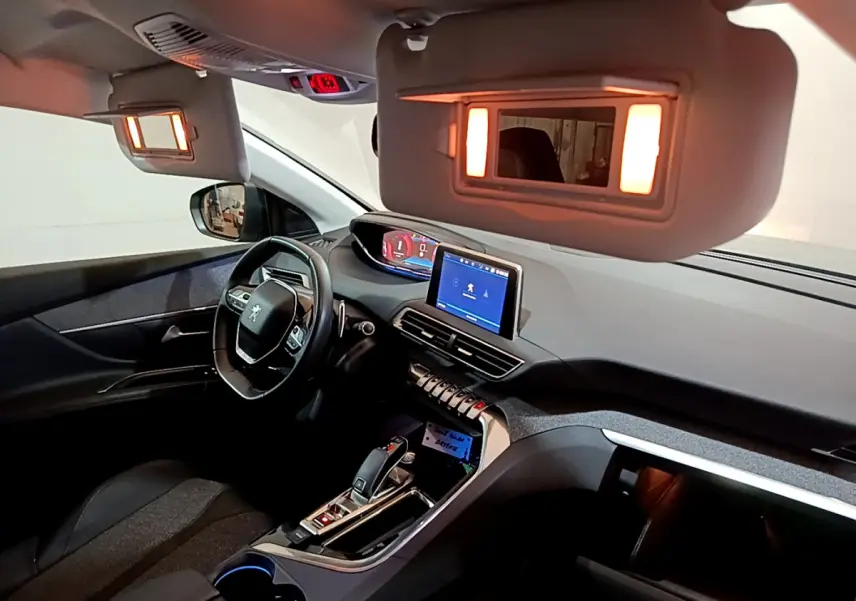 Intérieur du Peugeot 5008 2020 vu côté conducteur, tableau de bord avec écran tactile et miroirs de courtoisie éclairés.