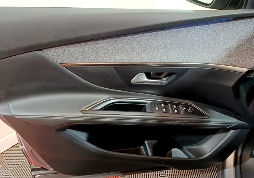 Intérieur côté gauche de porte PEUGEOT 5008 gris clair avec commandes de vitres et poignée métallique.