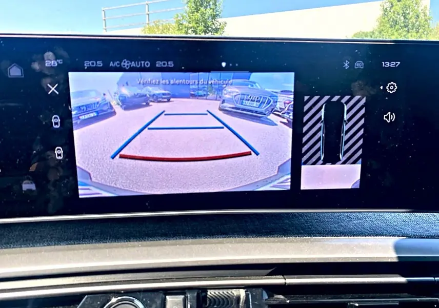 Écran tactile intérieur montrant la caméra de recul et l’aide au stationnement du Peugeot 5008 gris Artense.