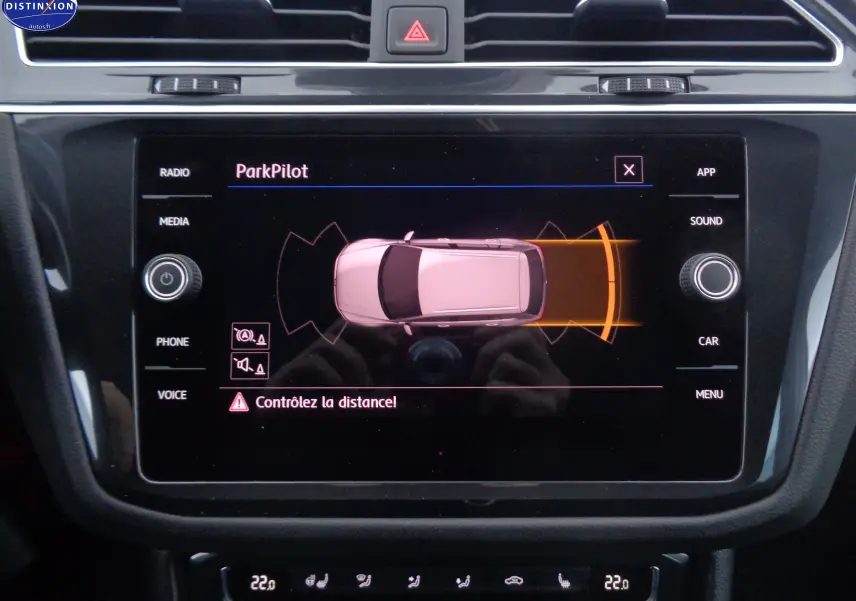 Écran central du Volkswagen Tiguan blanc 2019 montrant l'alerte ParkPilot avec détection d'obstacle arrière en orange.