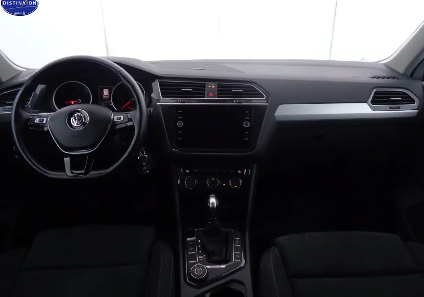 Intérieur noir du Volkswagen Tiguan 2019, vue frontale du tableau de bord avec volant multifonction et écran central éteint.