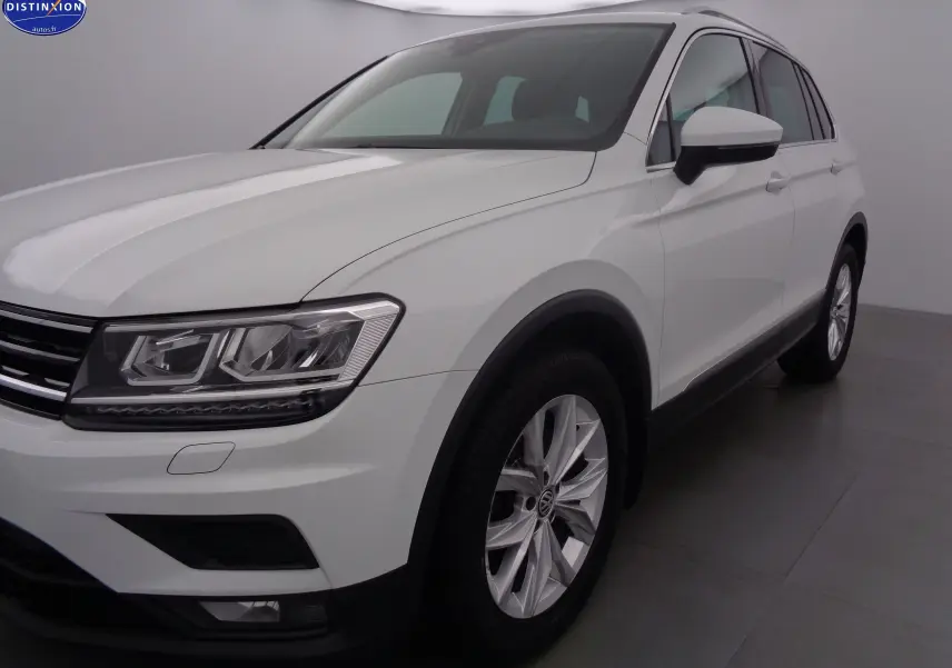 Volkswagen Tiguan blanc vu en 3/4 avant droit, mettant en valeur ses phares LED et jantes alliage.