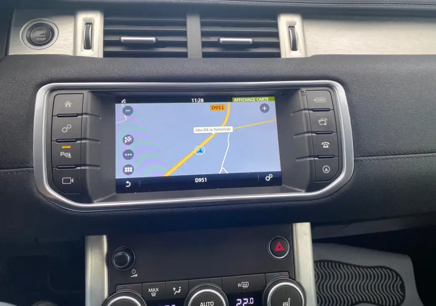 Tableau de bord noir du Range Rover Evoque 2016 avec écran GPS affichant une carte et commandes climatisation visibles