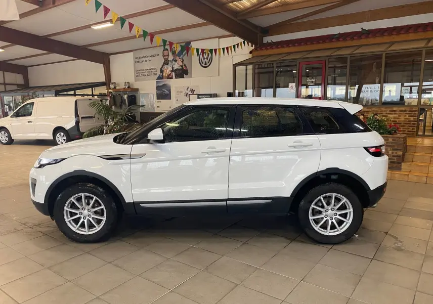 Profil droit du Range Rover Evoque blanc 2016 en intérieur, soulignant ses jantes alliage et lignes modernes.