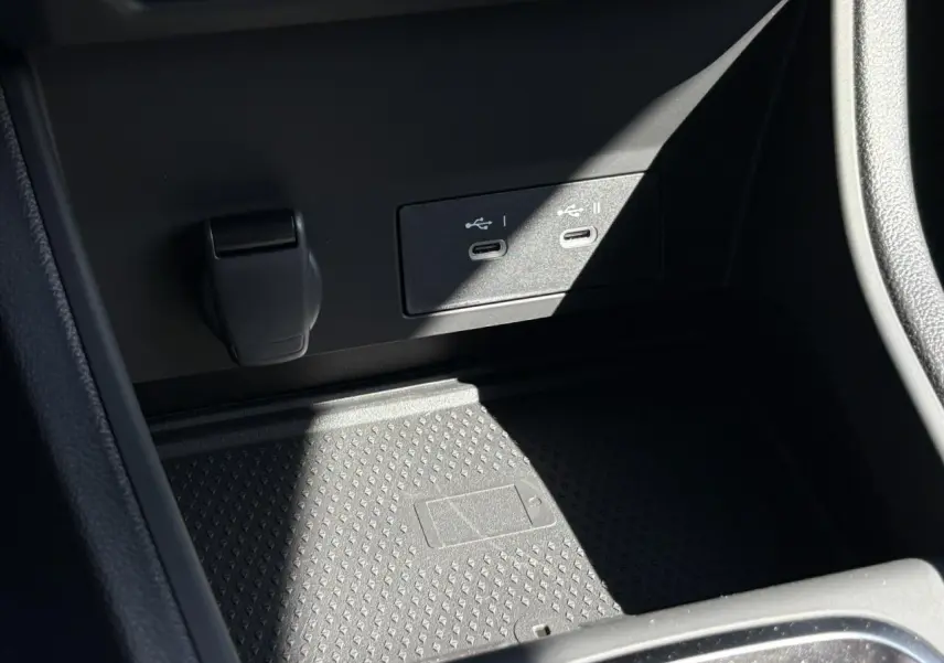 Gros plan sur la console centrale du Renault Captur 2025 avec ports USB-C et zone de charge sans fil noire.