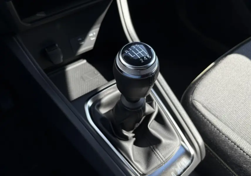 Le levier de vitesses manuel noir du Renault Captur 2025 vu de dessus, avec siège tissu gris à côté.