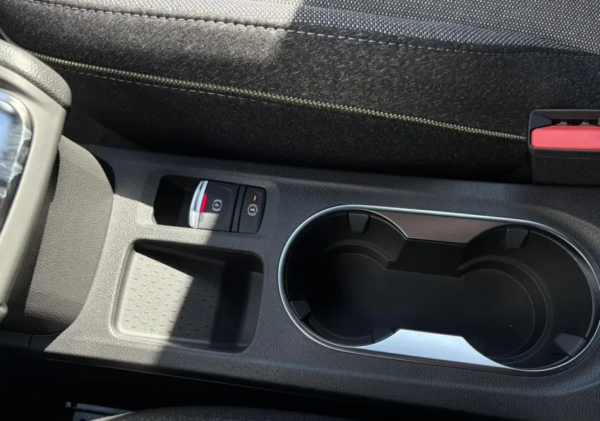 Gros plan sur la console centrale du Renault Captur Gris Rafale, avec porte-gobelets et frein à main électrique.