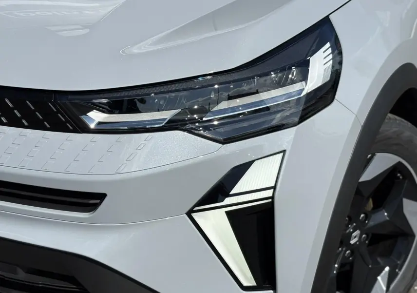 Gros plan sur le phare avant droit et la jante noire du Renault Captur Gris Rafale 2025 avec éclairage LED distinctif.