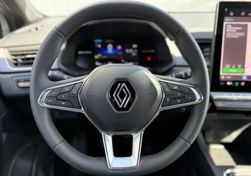 Volant en cuir perforé avec logo Renault, vu de face dans l'habitacle du Renault Captur 2025.