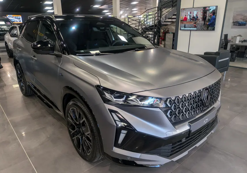 Renault Austral full hybride gris schiste satin avec toit noir, vue 3/4 avant en showroom lumineux.