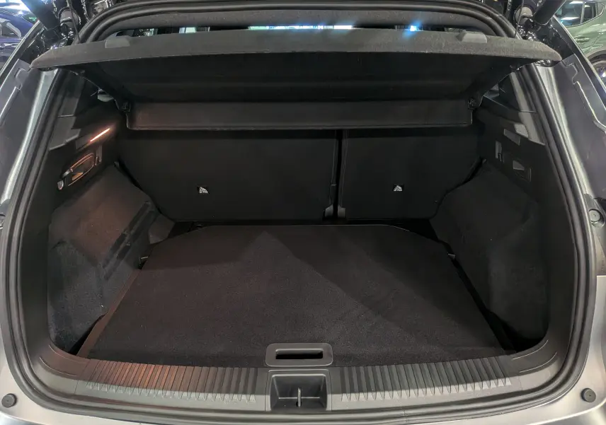 Coffre ouvert d'un Renault Austral gris schiste satin, vue arrière montrant l'espace de chargement noir et la tablette cache-bagages.