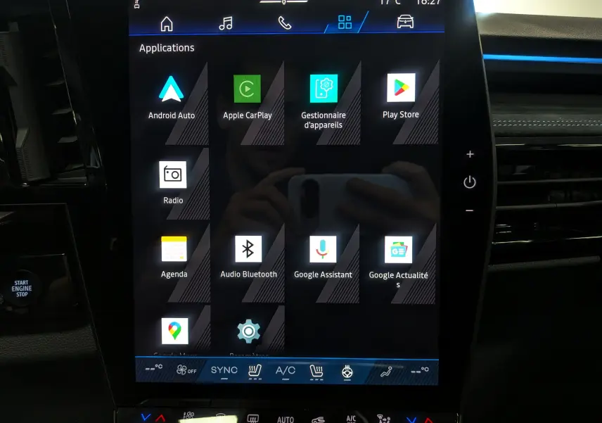 Écran tactile central du Renault Austral 2025 hybride, affichant les applications connectées dans l'habitacle noir.