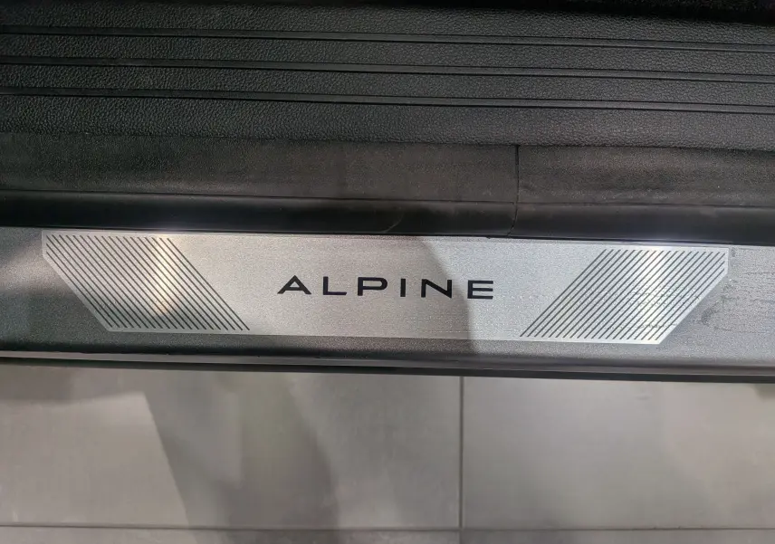 Gros plan sur la plaque de seuil de porte "ALPINE" du Renault Austral gris Schiste Satin version Esprit Alpine.