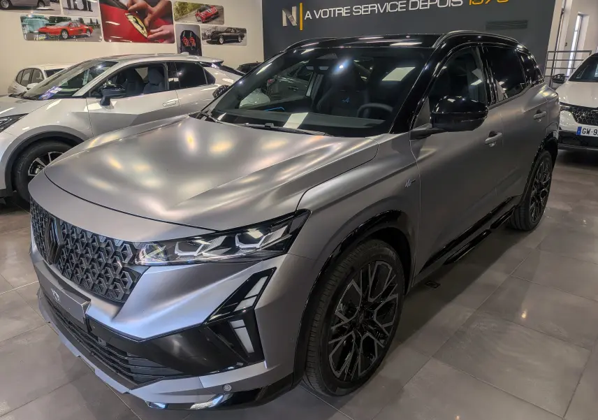 Renault Austral full hybride gris schiste satin avec toit noir, vue 3/4 avant mettant en valeur ses phares LED et jantes noires.