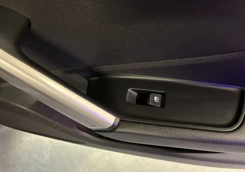 Gros plan sur le bouton de commande de lève-vitre côté intérieur d'une porte noire d'Audi Q2 35 TFSI S-Line 2023.