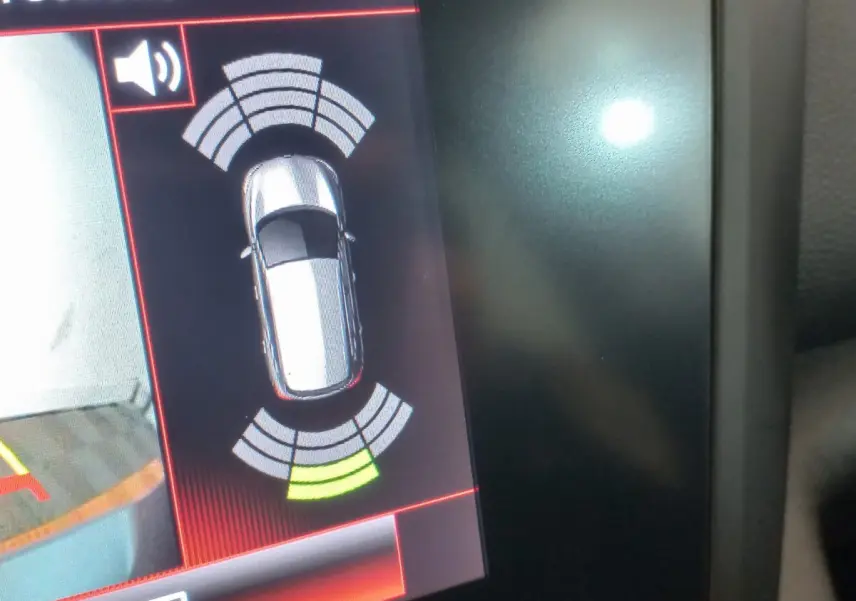 Affichage du système d'aide au stationnement montrant une Renault Kadjar gris foncé vue de dessus sur l'écran tactile.