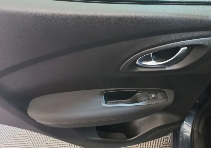 Intérieur côté gauche de la porte avant gris foncé du Renault Kadjar Business 2022 avec poignée et commande de vitre électrique.