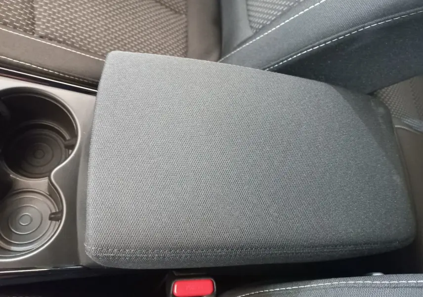 Gros plan sur l'accoudoir central en tissu gris foncé et porte-gobelets du Renault Kadjar Business 2022.