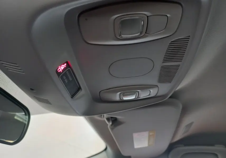 Vue intérieure du plafond avant du Renault Kadjar gris foncé, avec éclairage et témoin airbag passager allumé.