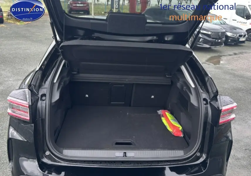 Vue arrière ouverte sur le coffre spacieux d'une Citroën C4 noire 2025, avec trappe à skis visible à l'intérieur.
