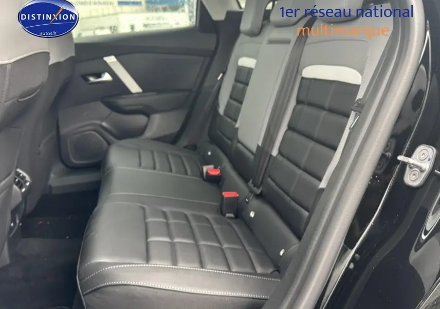 Vue intérieure côté droit sur la banquette arrière noire en cuir du Citroën C4 hybride 2025 avec porte ouverte.