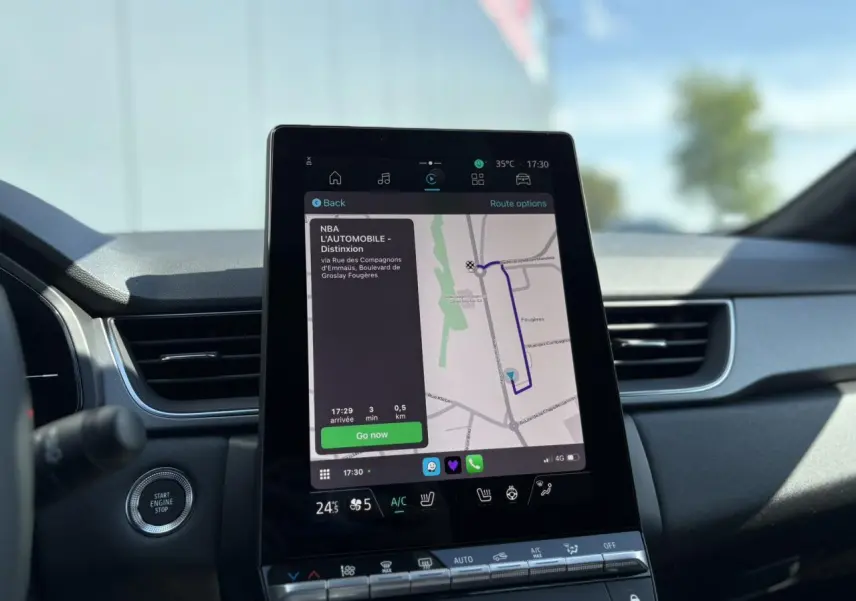 Écran tactile central du tableau de bord du Renault Captur blanc nacré 2025 affichant la navigation GPS.