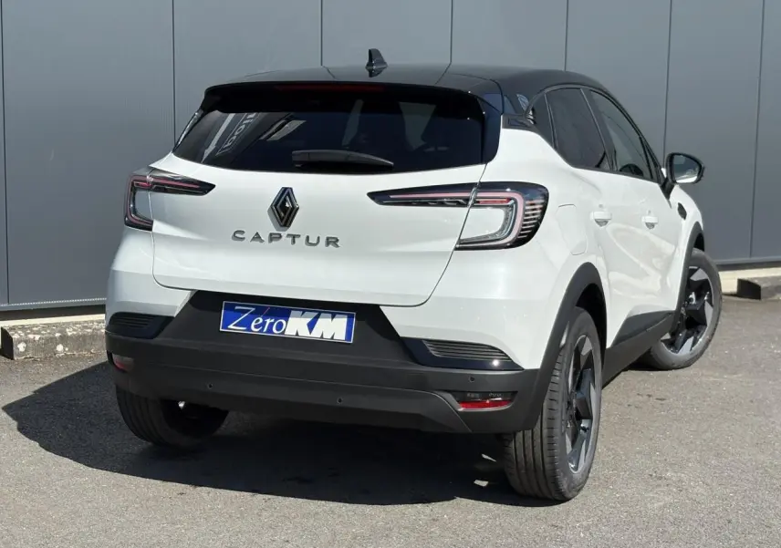 Vue 3/4 arrière droite du Renault Captur blanc nacré avec toit noir étoilé et jantes aluminium 18 pouces.