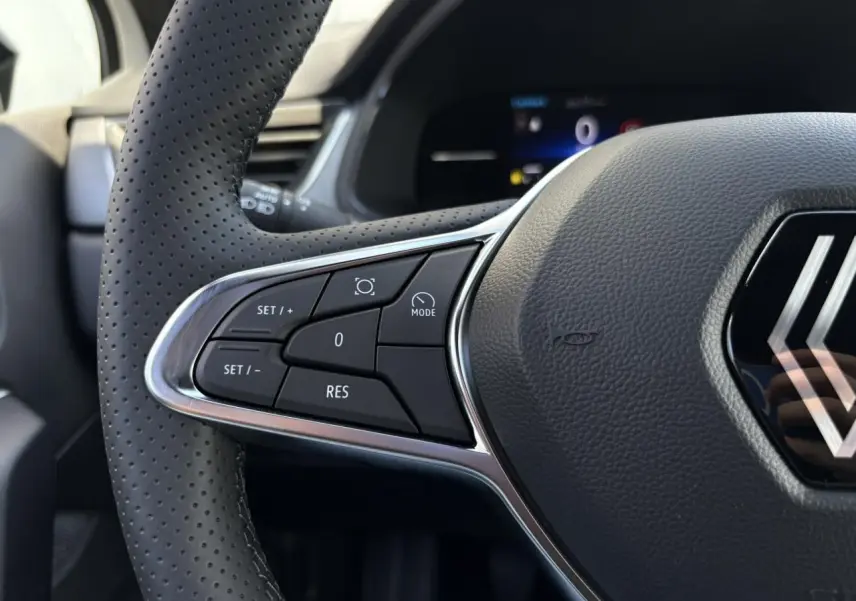 Gros plan sur le volant perforé à commandes intégrées du Renault Captur blanc nacré 2025, version ECO-G 100 Techno.