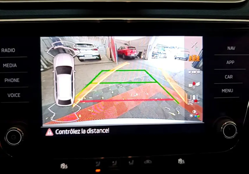Affichage caméra de recul avec vue arrière et guidage coloré sur écran tactile d'une Skoda Superb gris clair de 2020