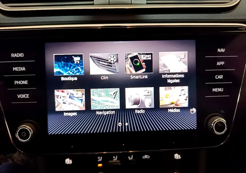 Écran tactile central allumé de la Skoda Superb 2020, affichant le menu multimédia avec commandes autour.