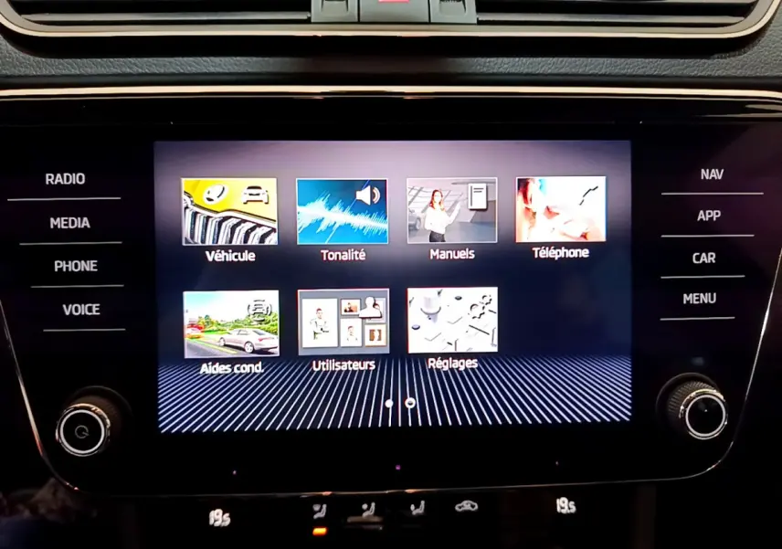 Écran tactile central affichant le menu multimédia de la Skoda Superb 2020, avec commandes autour et finition noire brillante.