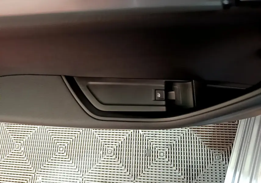 Détail de la poignée intérieure de porte côté droit d'une Skoda Superb gris clair, avec bouton de verrouillage.