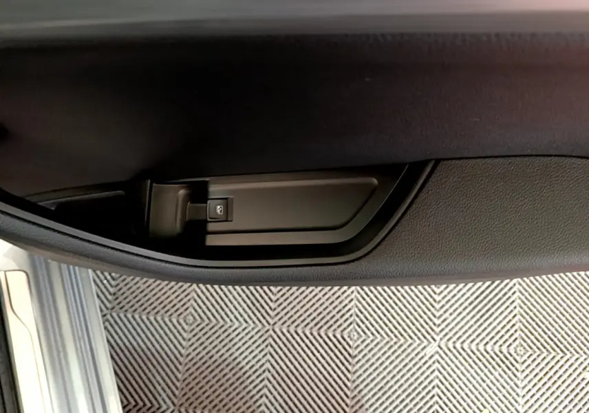 Détail de la poignée intérieure de porte côté conducteur d'une Skoda Superb gris clair 2020.