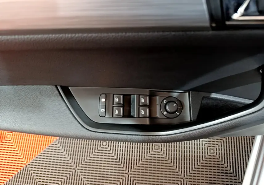 Commandes électriques des vitres et réglage des rétroviseurs sur la porte côté conducteur d'une Skoda Superb gris clair 2020.